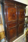 A 19th Century mahogany wardrobe with two doors enclosing hanging space and drawers on a plinth