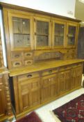 A pine kitchen dresser with four glazed doors to top over four drawers and four cupboard doors