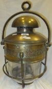 A brass oil lamp with glass shade bearing maker's plaque "J & A. Ridsdale Lamp Makers"