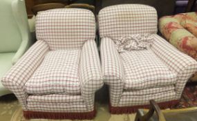 A pair of early 20th Century scroll arm armchairs, raised on bun feet, upholstered in cream and