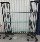 A glass and iron three shelf open display stand with cast iron columnar supports and glass shelves