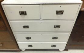 A white painted campaign chest of two short and three long graduated drawers with brass handles