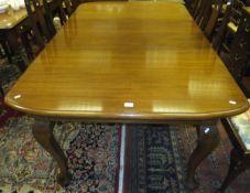 A rectangular mahogany extending dining table with two extra leaves on cabriole legs to pad feet