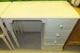 A cream painted pine dressing table with bank of four drawers and two turned and ringed legs