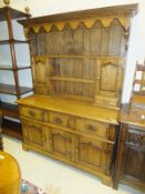 An oak dresser in the 18th Century manner, the plate rack above three drawers over two panelled
