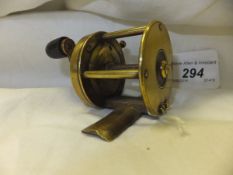 A Victorian brass multiplying crank wind reel with enclosed gear housing and stop lever