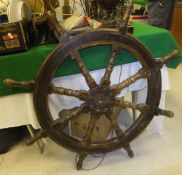A teak ship's wheel, a model of a ship, a "globe" table lamp and a ship's ensign