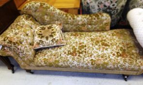 A Victorian upholstered chaise longue with serpentine back rail on turned legs to brass castors
