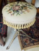 A late 19th/early 20th century brass framed adjustable piano stool with circular upholstered top