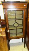 An Edwardian mahogany and inlaid display cabinet, the single astragal glazed door enclosing shelves,