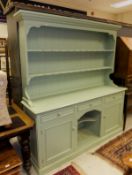 A green painted pine dresser with boarded plate rack above a base of three drawers over central