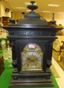 A circa 1900 ebonised cased mantel clock, the domed top with dragon scale decoration over an