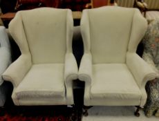 A pair of early to mid 20th century upholstered wing back scroll armchairs