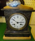 A black marble cased mantel clock with cream marble pediment and base with Roman numerals to the