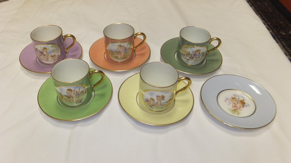 A collection of five Royal Worcester coffee cans and saucers depicting cherubs, together with two