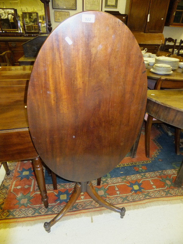 A Regency mahogany oval occasional table, the snap top on turned and vase shaped pedestal to splayed