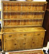 A 19th century dresser, the plate rack above three various drawers over four panelled doors to a