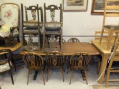 A set of six Ercol wheel and stick back kitchen chairs, shaped rectangular elm dining table on