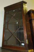 A mahogany single glazed door corner cupboard opening to reveal various shelving