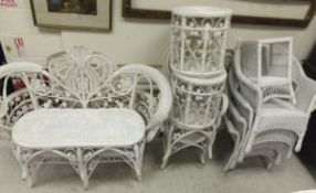 A collection of white painted wicker work garden / conservatory furniture comprising a set of four