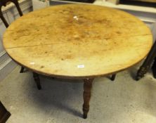 A circular pine dining table on ringed and turned supports