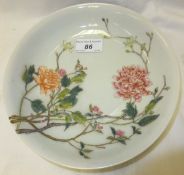 A Chinese porcelain shallow dish, polychrome decorated with flowering branches, bearing under
