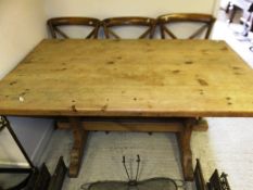 A modern pine refectory style kitchen table on end trestle supports united by a centre stretcher
