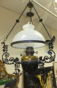 A ceiling light fitting with opaque glass shade, clear glass chimney, brass body and iron frame in