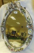 A late 19th Century Dresden porcelain oval wall mirror with cherubic and floral encrusted