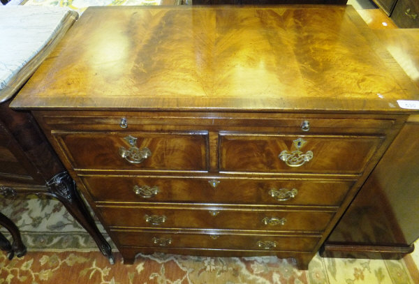 A mahogany bachelor chest with brushing slide and two short over three long drawers, raised on swept