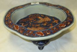 A Chinese porcelain shaped bowl decorated in iron red and cobalt blue with dragons and cloud motifs,