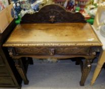 A Victorian carved oak Gothic Revival single drawer side table with mask and mythical beast head