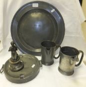 A pewter charger, together with two 19th Century pewter mugs (converted to jugs), a pewter plate