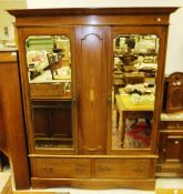 An Edwardian mahogany herringbone strung wardrobe, the moulded cornice over a pair of shaped