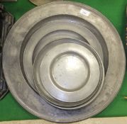 A large pewter platter stamped with the initial "R" above the initials "EM" and seven assorted