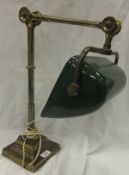 A brass bodied desk lamp with a green coloured enamelled shade