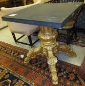 A gilt centre table raised on central column to four profusely decorated legs, with square slate