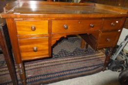 A Victorian mahogany kneehole dressing table / desk with central drawer flanked by two banks of