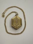 A 9 carat gold locket with engraved floral decoration and empty cartouche, housed on a 9 carat