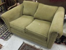 A modern scroll arm two seat sofa upholstered in a beige chenille style fabric