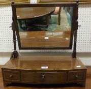 A 19th Century mahogany toilet mirror, the rectangular plate on a bow fronted base of three drawers