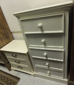 A modern cream painted chest of five drawers and a bedside chest of three drawers standing on