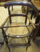 A child's high chair with cane seat on turned legs united by stretchers