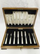 A cased set of eight George V silver bladed mother of pearl handled fruit knives and forks (