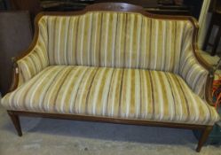A late 19th / early 20th Century walnut framed settee in the Empire taste upholstered in cream and