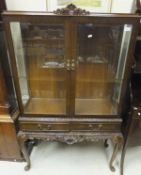 A modern mahogany and carved display cabinet in the Chippendale taste