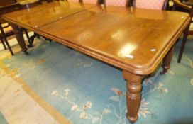 A Victorian mahogany rectangular extending dining table, the top with moulded edge and two extra