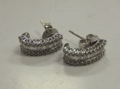 A pair of white gold and baguette cut diamond earrings