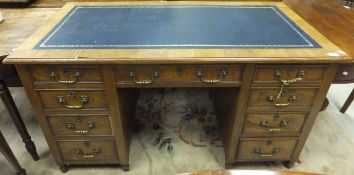 A circa 1900 oak double pedestal desk, the top with tooled and gilded leather insert above a central