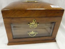 A late Victorian walnut jewellery casket, the rising lid over a bevelled edge glazed front,